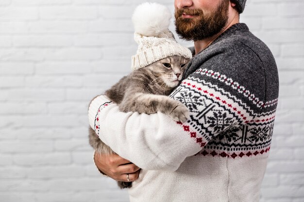 Photo gratuite homme avec chaton portant un bonnet de fourrure pour l'hiver