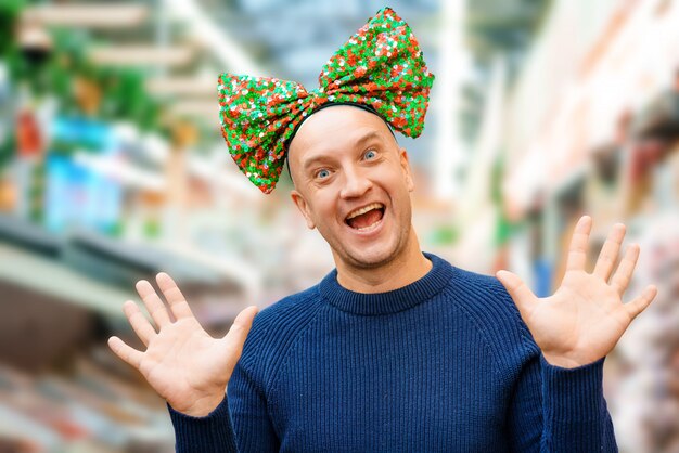 Homme chauve drôle avec un arc sur la tête, ambiance festive