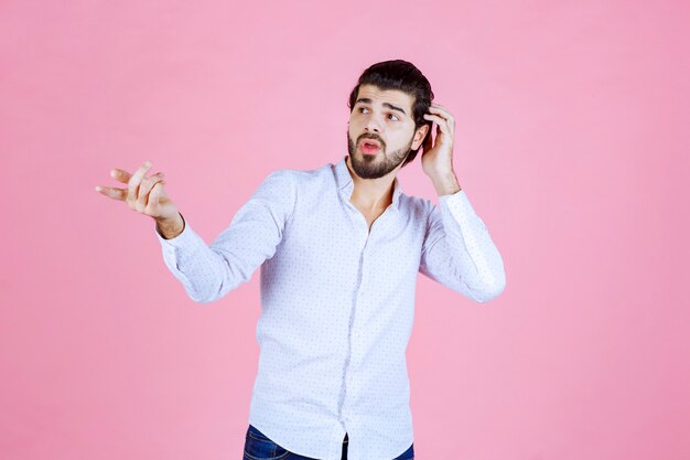 L'homme en chemise blanche a l'air confus et perdu.