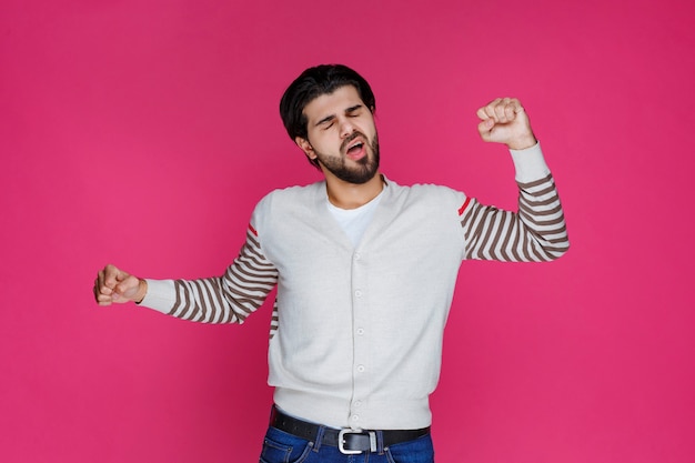 L'homme en chemise blanche a l'air épuisé et endormi.