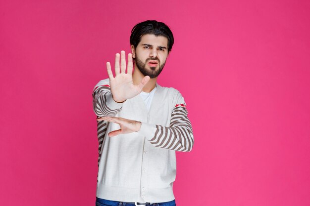 Homme en chemise blanche arrêtant ou empêchant quelque chose.