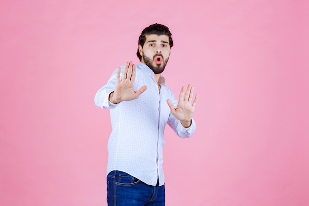 Homme en chemise blanche arrêtant quelque chose.