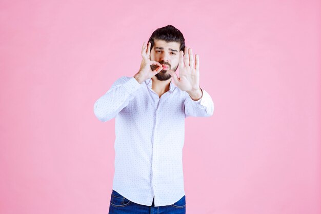 Homme en chemise blanche arrêtant quelque chose.