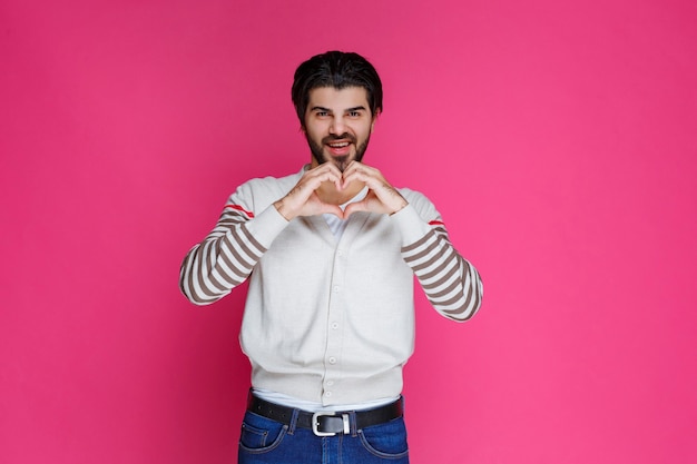 Homme en chemise blanche envoyant l'amour aux fans.