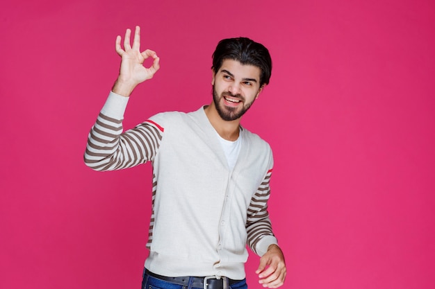 Homme en chemise blanche faisant signe de main ok ou perfection.