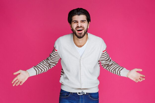 Homme en chemise blanche faisant signe à un visage souriant et joyeux.