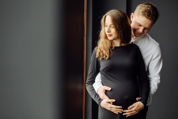 Homme en chemise blanche et femme en robe noire Photo de grossesse