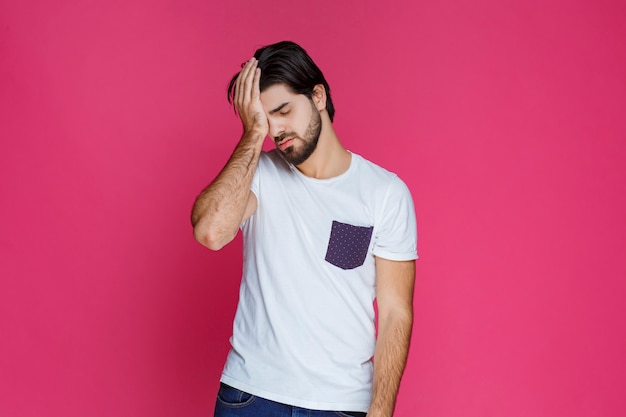 Photo gratuite l'homme en chemise blanche ne peut pas se retenir de dormir debout.