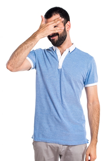 Un homme avec une chemise bleue couvrant son visage