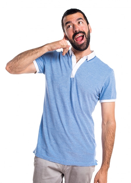 Homme avec une chemise bleue faisant un geste téléphonique