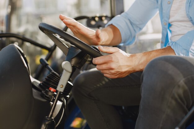 Homme en chemise bleue. Guy dans un tracteur. Machines agricoles.