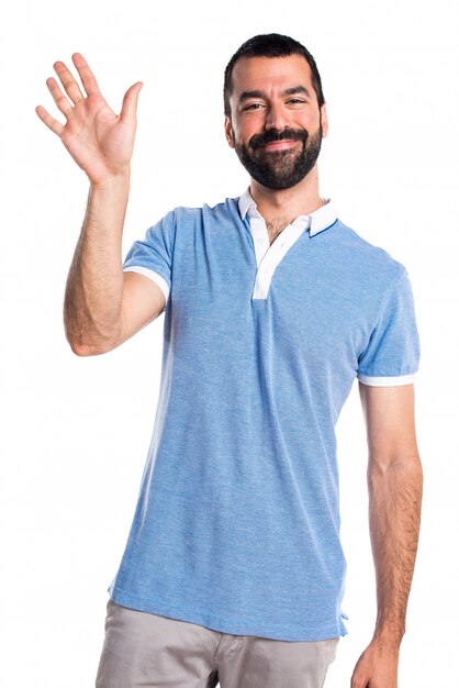 Un homme avec une chemise bleue saluant