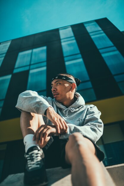 Homme en chemise grise portant une casquette noire et blanche