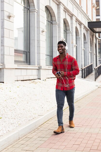 Homme en chemise rouge marchant long shot