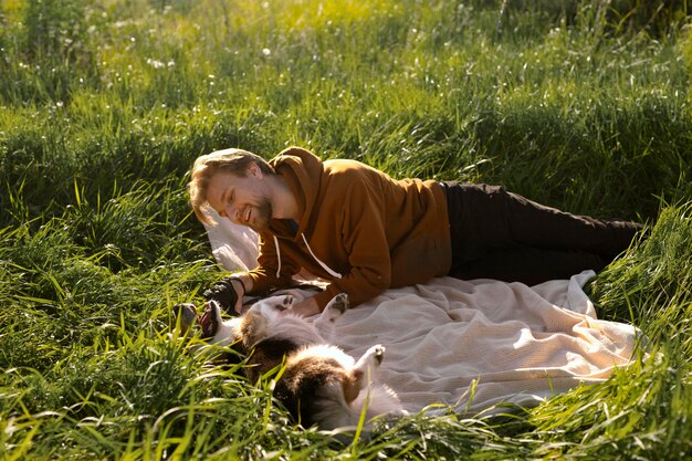 Photo gratuite homme, à, chien, sur, couverture, plein coup