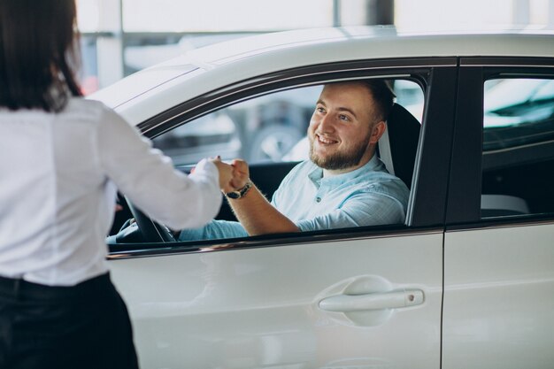 Homme choisissant une voiture dans une berline de voiture