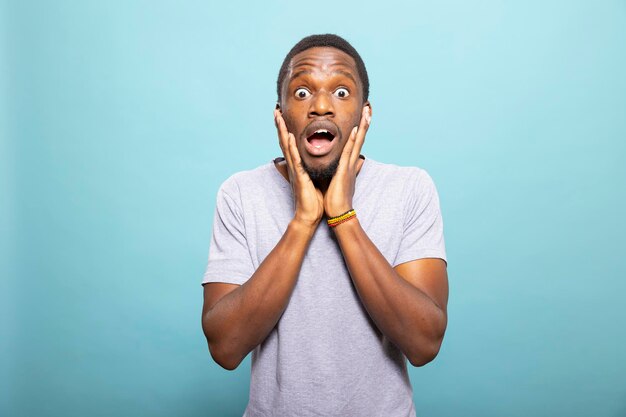Un homme choqué tenant son visage