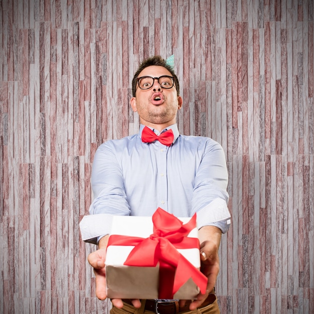 Photo gratuite l'homme coiffé d'un chapeau rouge noeud papillon et partie. offrant un cadeau.