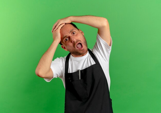 Photo gratuite homme de coiffeur en tablier à la fatigue et surmené debout sur un mur végétal