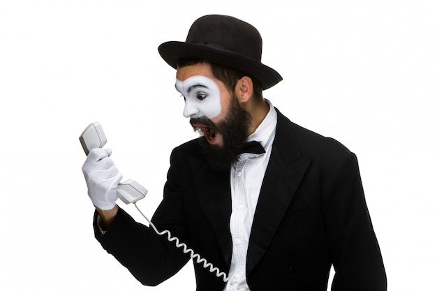 Un homme en colère et irrité hurle dans le combiné téléphonique