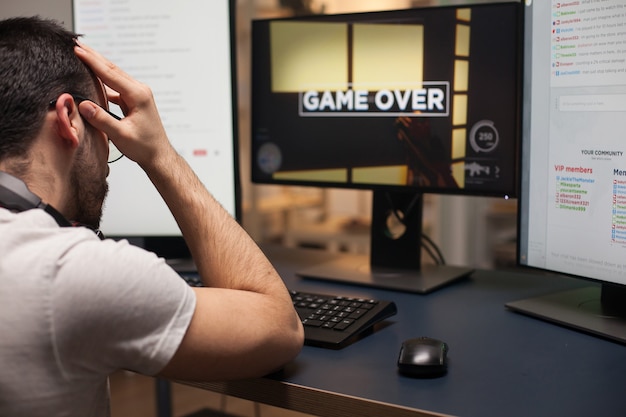 Homme en colère avec des lunettes après sa perte sur un jeu de tir en ligne. Jeu terminé pour l'homme compétitif.