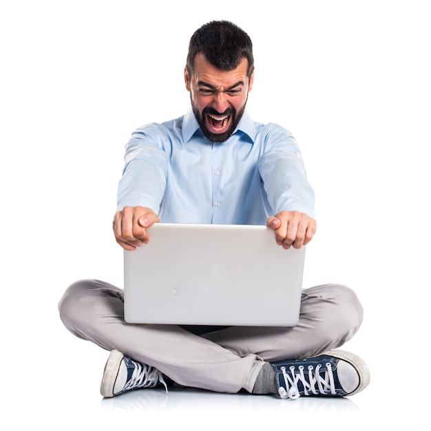 Homme en colère avec un ordinateur portable criant