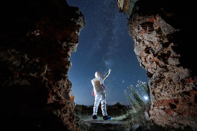 Homme en combinaison spatiale blanche spéciale explorant les étoiles