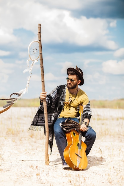 Homme comme hipster boho contre le ciel bleu