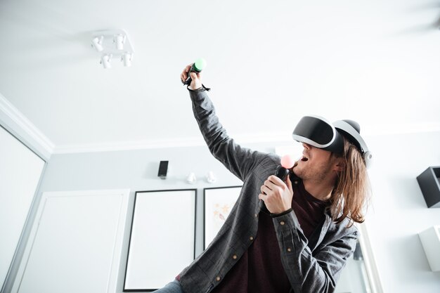 Homme concentré assis à la maison à l'intérieur jouer à des jeux