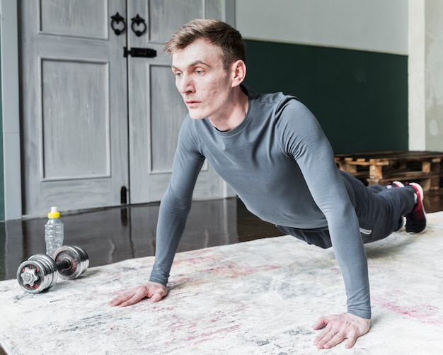 Homme concentré faisant des pompes