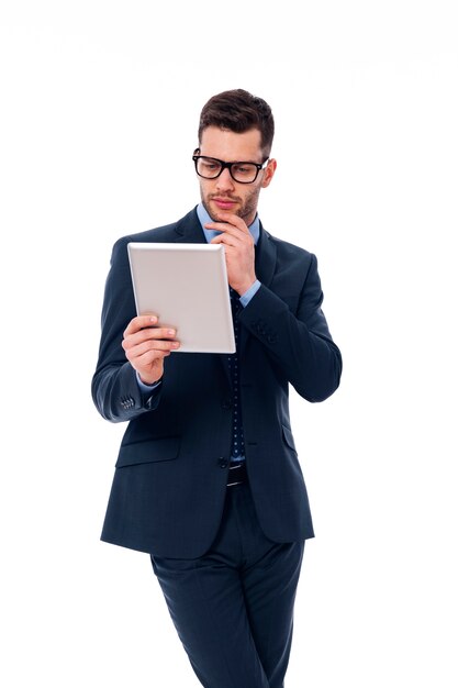 Homme concentré travaillant avec une tablette numérique