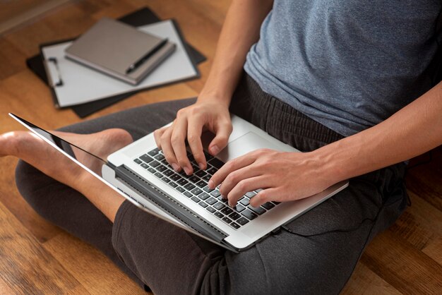 Homme confortable utilisant un ordinateur portable à la maison en quarantaine pour travailler