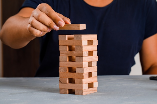 Photo gratuite homme construisant la tour de blocs de bois.