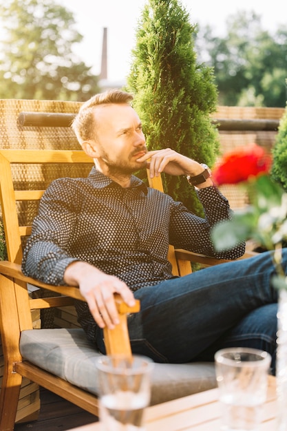 Photo gratuite homme contemplé assis au balcon