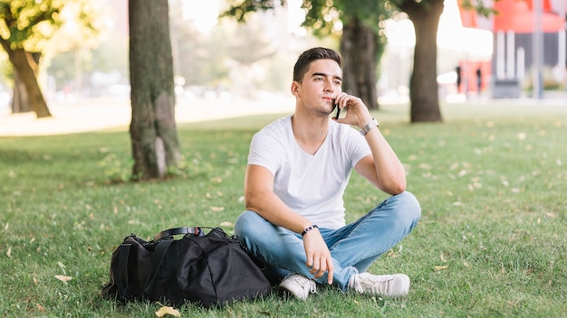 Homme contemplé assis sur l&#39;herbe dans le jardin