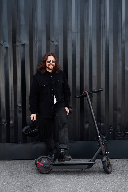 Homme cool plein coup s'amusant avec un scooter