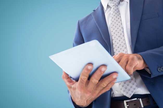 Homme en costume et cravate avec une tablette