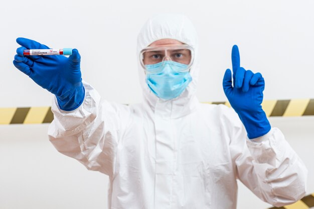 Homme en costume hazmat avec échantillon de sang