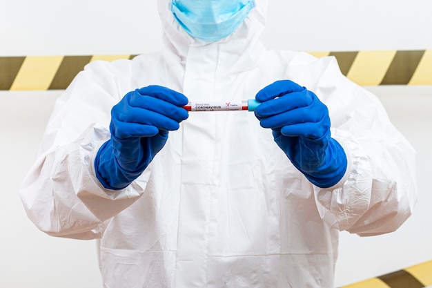 Homme en costume hazmat avec échantillon de sang