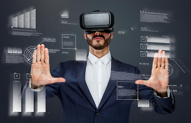 Homme en costume avec des lunettes de réalité virtuelle sur la tête travaillant dans le monde financier virtuel.