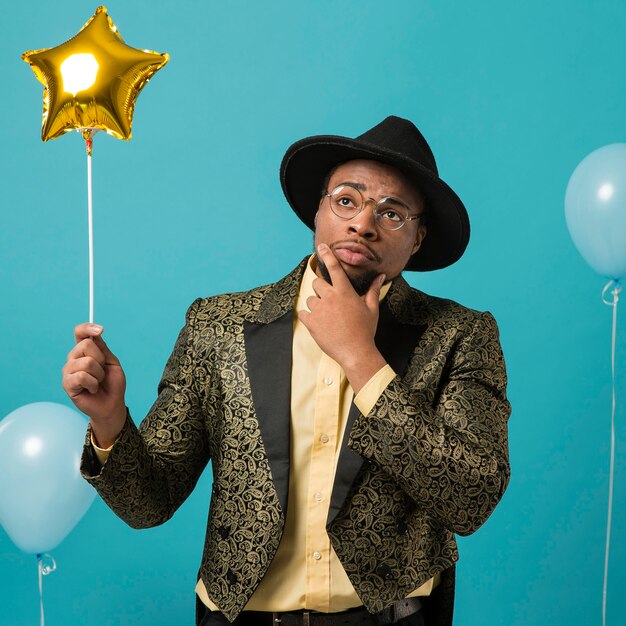 Homme en costume et lunettes de soleil à la fête avec ballon