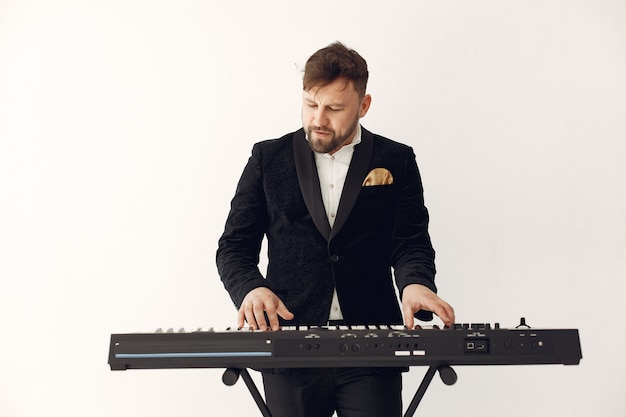 Photo gratuite homme en costume noir debout avec un clavier électro