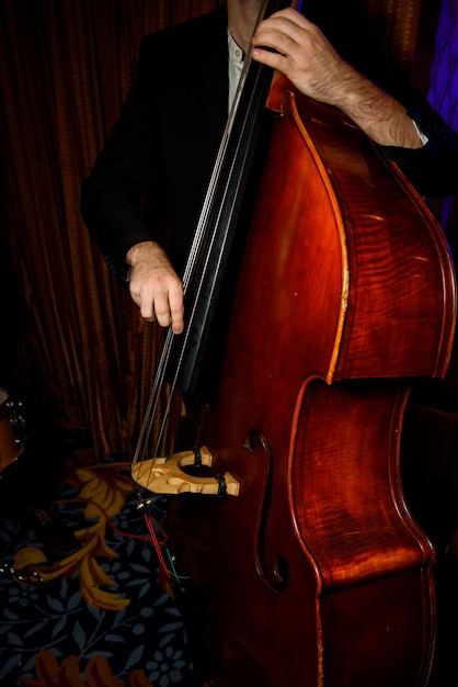 Photo gratuite l'homme en costume noir joue sur le violoncelle