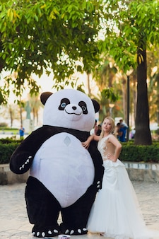Un homme en costume de panda réconforte une femme blessée qui marche dans la ville