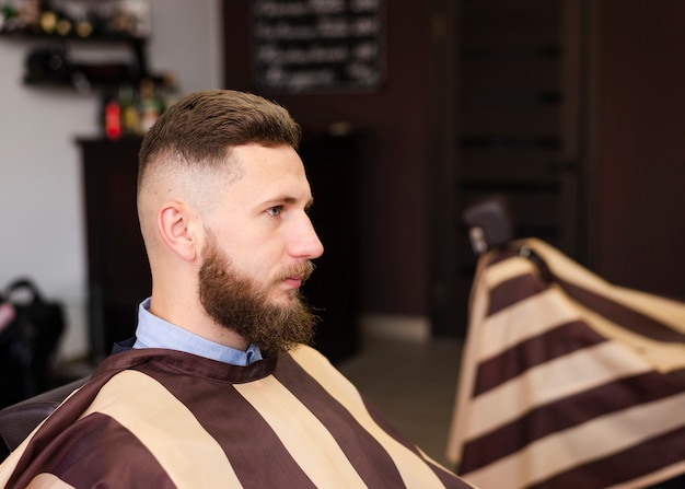 Photo gratuite homme sur le côté en attente d'une nouvelle coupe de cheveux