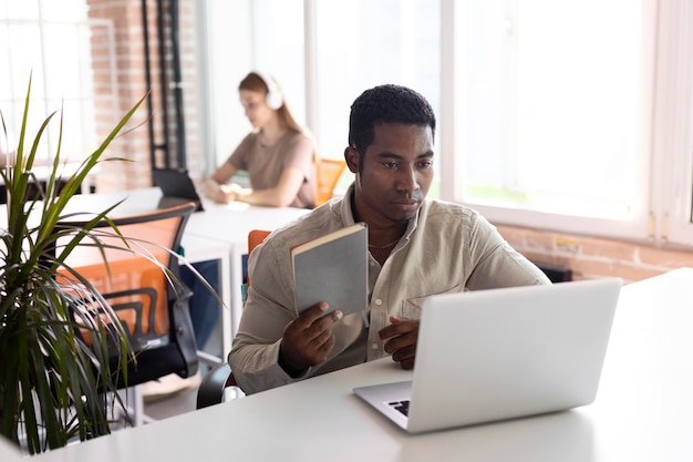 Homme de coup moyen au travail avec un ordinateur portable