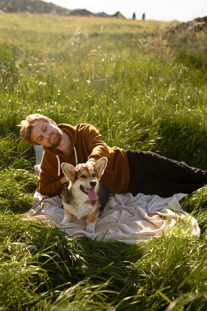 Photo gratuite homme de coup moyen avec chien dans la nature