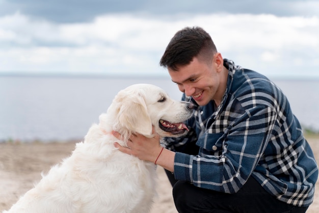 Photo gratuite homme de coup moyen avec un chien mignon à l'extérieur