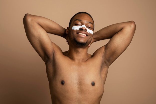 Photo gratuite homme de coup moyen avec de la crème pour le visage