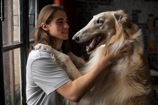 Photo gratuite homme de coup moyen avec un mignon chien lévrier